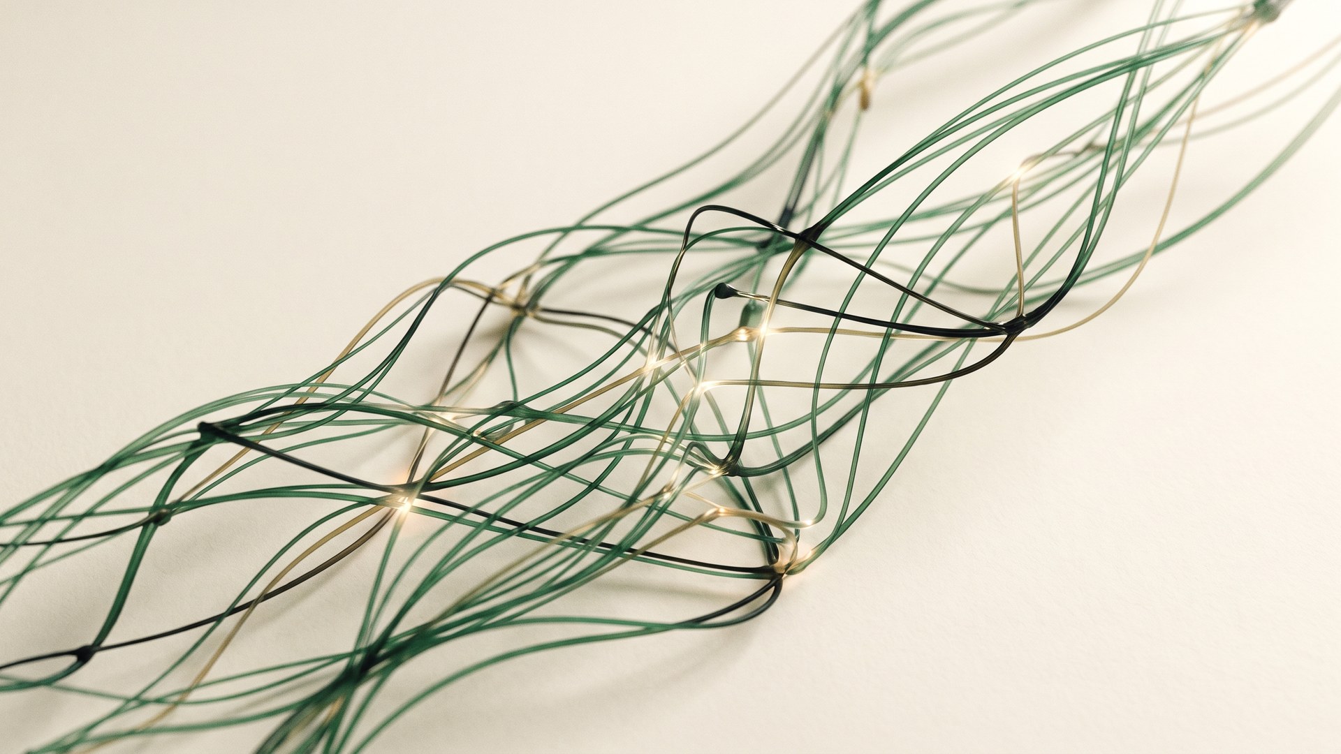 Green and brass strands join at glowing points on a cream background, illustrating connected knowledge.